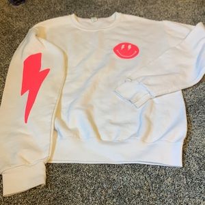White smiley face crewneck with lightning bolt on the sleeve size small